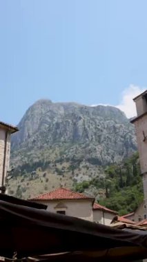 Karadağ 'ın Kotor kentinde, canlı yeşil kapısı ve çiçek aksanıyla kırsal mimari sergilenen büyüleyici bir geleneksel taş ev. Bu yapı şehrin özünü ve tarihsel özünü yansıtır.