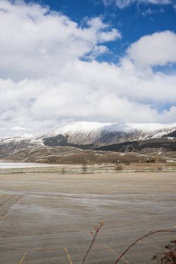 Roccaraso, İtalya 'nın muhteşem manzarası. Arkasında karla kaplı dağlar var. Uçsuz bucaksız açık alan ve dramatik gökyüzü Apeninler 'deki bu kış mevsiminin huzurlu güzelliğini gözler önüne seriyor.