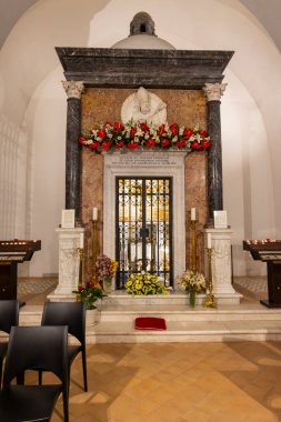 Maratea 'daki San Biagio Bazilikası' nın içinde kasabanın koruyucu azizi Saint Blaise 'in süslü mezarını sergiliyoruz. Mermer yapı çiçekler, mumlar ve işlenmiş demir bir kapı ile süslenir. Kutsal ve kutsal bir atmosfer yaratır. 