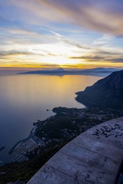 Basilicata, Maratea 'dan Tyrhenian Denizi üzerinde nefes kesici gün batımı manzarası. Sudaki altın yansımalar, dağlık kıyı şeridi ve huzurlu gökyüzü bu manzarayı İsa 'nın kurtarıcısı yakınlarındaki bir bakış açısından mükemmel bir an haline getiriyor.