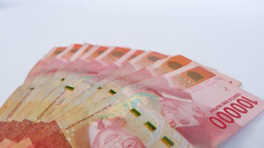 Beyaz bir paspasın üzerine yerleştirilmiş birkaç Endonezya banknotu. Endonezya 'nın para birimi Rupiah' tır