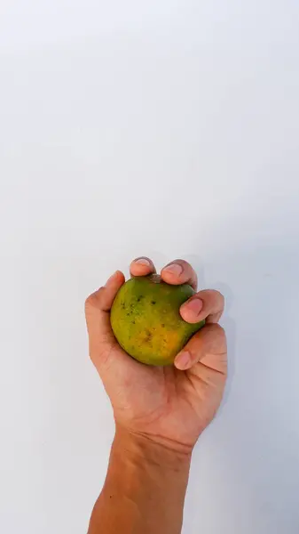 Mano Que Sostiene Una Naranja Entera Verde Sujetado Una Alfombra — Foto de Stock