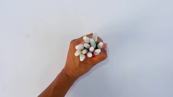Beyaz bir bloknotta birkaç renkli işaret tutan el..