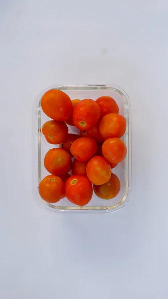 Cam bir kabın içine yerleştirilmiş kırmızı domatesler. Domates bir sebze türüdür..