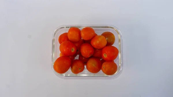 Cam bir kabın içine yerleştirilmiş kırmızı domatesler. Domates bir sebze türüdür..