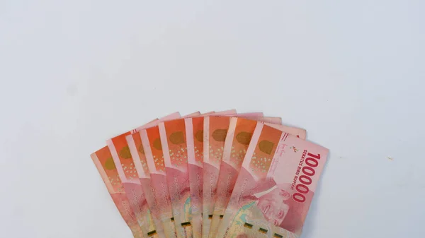 Beyaz bir paspasın üzerine yerleştirilmiş birkaç Endonezya banknotu. Endonezya 'nın para birimi Rupiah' tır