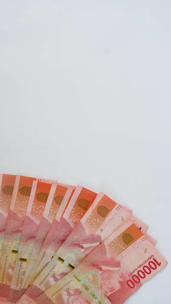 Beyaz bir paspasın üzerine yerleştirilmiş birkaç Endonezya banknotu. Endonezya 'nın para birimi Rupiah' tır