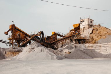 Taş ocağı makineleri ve mavi gökyüzünün üzerindeki çakıl yığınları. Taş parçalama ve tarama tesisi. Yüksek kalite fotoğraf