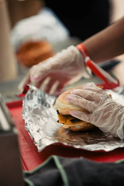 Müzik festivali sırasında bir yemek kamyonunda hamburger hazırlayan bir aşçının ellerine yakından bakın. Yüksek kalite fotoğraf
