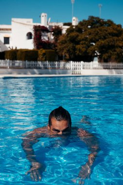 Genç adam yüzme havuzunda dinleniyor. Yüksek kalite fotoğraf