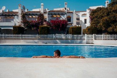 Genç adam yüzme havuzunda dinleniyor. Yüksek kalite fotoğraf