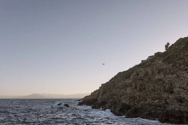 Ceuta 'daki Desnarigado sahilinde gün batımında deniz üzerinde uçan bir İHA görüntüsü. Yüksek kalite fotoğraf