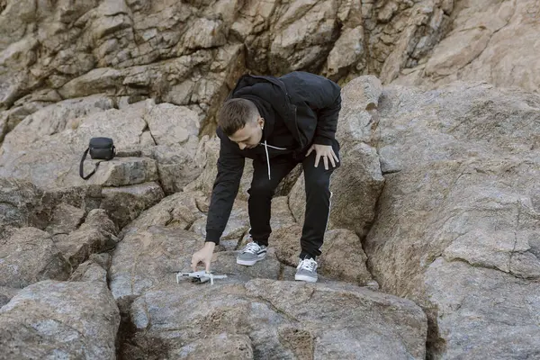 Genç adam deniz üzerinde bir dron çalıştırmaya hazırlanıyor. Yüksek kalite fotoğraf