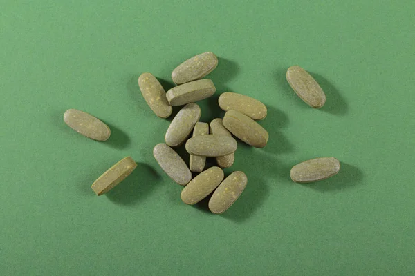 Herbal and Vitamin green pills healthy food freely laid on green background for healthy eating in daily life