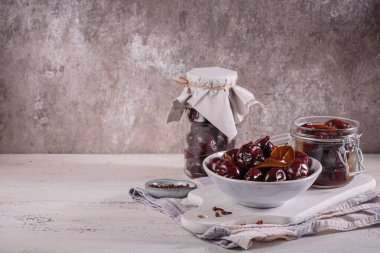 Preserving pickled plums in its own juice and seasonings on a wooden table. Healthy fermented food. Home canned vegetables.