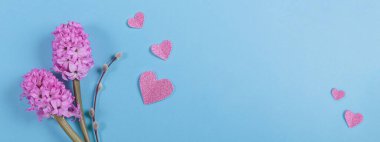 March eight Womens Day card from spring hyacinth flowers and number 8 with paper hearts long banner. Minimal greeting card for International Women Day on blue background