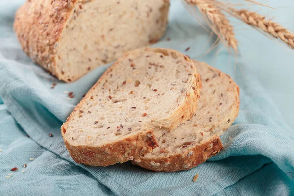 Gesneden Vers Gebakken Volkorenbrood Met Lijnzaad Sesamzaad Lichtblauw Bord Bakkerijproducten — Stockfoto