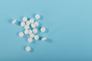 Herbal ve vitamin beyazı hapların üst görüntüsü sağlıklı gıdaların günlük hayatta sağlıklı beslenmek için açık mavi arka planda sergilenmesi