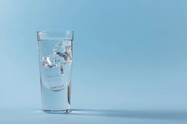 Copo Água Pura Fria Com Cubos Gelo Sobre Fundo Azul — Fotografia de Stock
