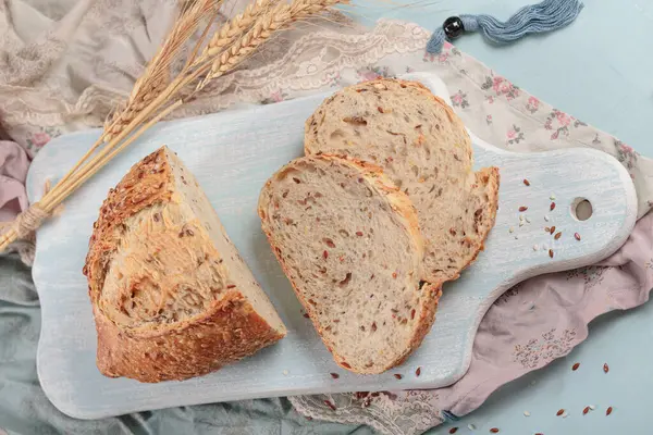 Gesneden Vers Gebakken Volkorenbrood Met Lijnzaad Sesamzaad Lichtblauw Bord Bakkerijproducten — Stockfoto