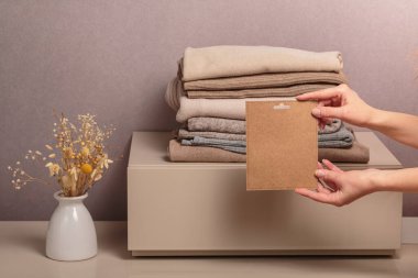 Giysi yığını, kullanılmış gardırop ve yazılı kart. İkinci el. Dairesel moda, hızlı moda, kıyafet geri dönüşümü, çevre dostu sürdürülebilir alışveriş, yeniden satış, ikinci el mağazaları konsepti