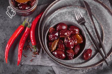 Preserving pickled plums in its own juice and seasonings on a wooden table. Healthy fermented food. Home canned vegetables.