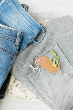 Bir yığın kot pantolon ve boş kağıt etiket. İkinci el giyim mağazası. Dairesel moda, çevre dostu sürdürülebilir alışveriş, bağış, ikinci el mağazaları konsepti. Etiket modeliyle üst görünüm