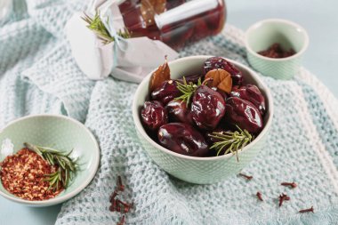 Marinated plums with spices in glass jar on the kitchen table. Homemade canning. Vegetable snack for winter.