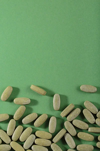 Herbal and Vitamin green pills healthy food freely laid on green background for healthy eating in daily life