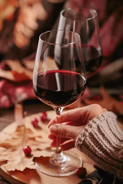 秋はまだ暗い木の背景に素朴なスタイルで赤ワインと乾燥葉の2つのメガネで生きています グラスを握るウォーマンス ロマンチックなセーター天気 ワインテイスティングコンセプト — ストック写真