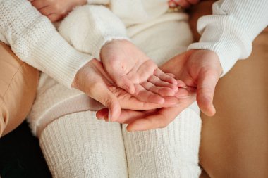 Avuçlarını büken üç kişiye yaklaş. Baba, anne ve kız el ele tutuşuyorlar. Jest, destek ve sevgi işareti, birlik, birliktelik, göreceli insanlar konsepti. Aile Günü