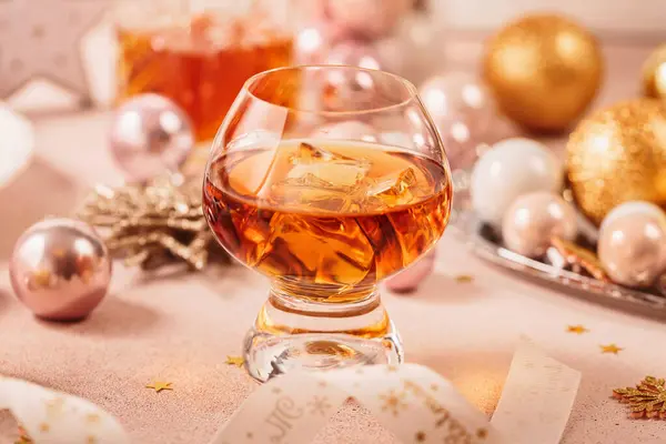 Glas Whiskey Oder Bourbon Mit Festlicher Weihnachtsdekoration Auf Hellbeigem Hintergrund Stockbild
