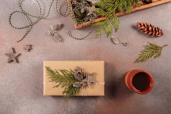 Winter holiday mood, Merry Christmas, Happy New Year background. Preparation for holidays. Wooden box with Christmas decor and handmade gift box. Flat lay, top view