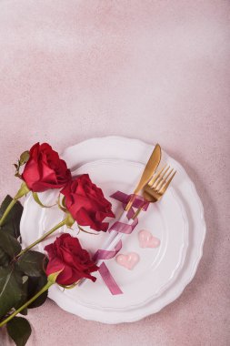 Kırmızı güllerle Sevgililer Günü için şenlik masası. Romantik sevgililer günü yemeği konsepti. Randevu için davetiye. Üst görünüm, kopyalama alanı olan düz uzanma