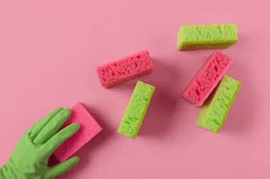 Mutfak, banyo ve pembe arka plandaki diğer odalar için temizlik seti. Çamaşır süngeri tutan kauçuk eldiven. Temizlik konsepti, profesyonel temizlik, ev malzemeleri.