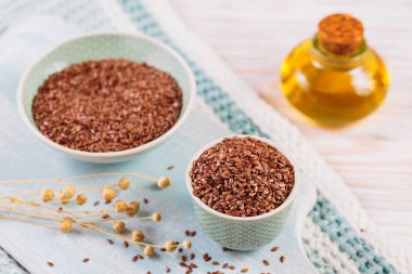 Kahverengi keten tohumu, keten tohumu, beyaz ahşap arka planda sebze yağı. Sağlıklı süper yiyecekler