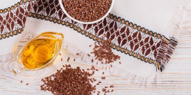 Kahverengi keten tohumu, keten tohumu sebze yağı, beyaz kırsal ahşap arka planda. Sağlıklı süper yemek afişi, üst manzara, düz yatak