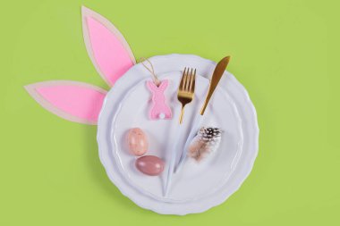 Masa takımı ve pastel yeşil arka planda neşeli paskalya dekoru. Mutlu Paskalyalar ya da davetiyeler. Üst manzara, düz uzanma,