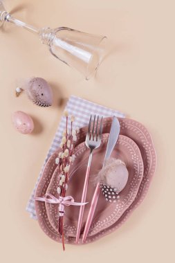 Pastel bej arka planda paskalya yumurtaları olan masa dekoru ve şenlik dekoru yerleştirin. Mutlu Paskalyalar ya da davetiyeler. Üst manzara, düz uzanma