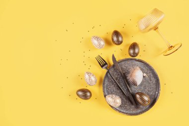 Masa takımı, boş bardak ve sarı arka planda neşeli paskalya dekoru. Mutlu Paskalyalar ya da davetiyeler. Üst görünüm, düz görünüm, metin için alanı kopyala
