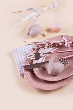 Pastel bej arka planda paskalya yumurtaları olan masa dekoru ve şenlik dekoru yerleştirin. Mutlu Paskalya kutlamaları ya da davetiyeler