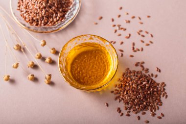 Kahverengi keten tohumu, bej arka planda keten tohumu bitkisi yağı. Sağlıklı süper yiyecekler