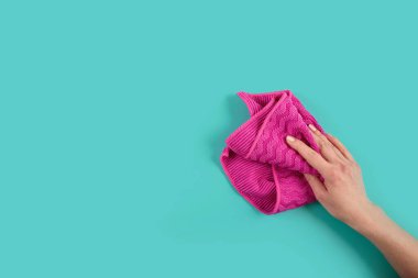 Mavi arka planda kadınların el ele tutuştuğu paçavra. Temizlik konsepti, profesyonel temizlik, ev malzemeleri. Üst görünüm, kopyalama alanı olan düz uzanma