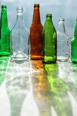 Yaratıcı gölgeleri olan boş şişeler ve fantastik röfleler. Geri dönüşüme hazır farklı cam konteynırların atıkları. Ayrı bir cam çöplük koleksiyonu. Çevre dostu ve sıfır atık kavramı