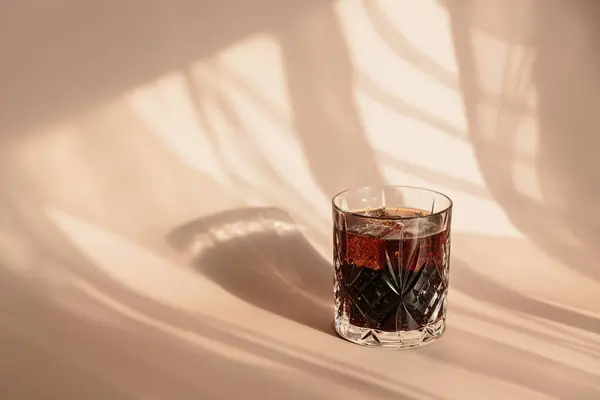 威士忌可乐鸡尾酒 高球杯中浓郁的酒精和冰块 背景浅浅的米黄色 有阴影和迷人的亮点 白天反射出明亮的阳光 — 图库照片