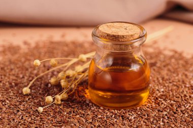 Kahverengi keten tohumu, bej arka planda keten tohumu bitkisi yağı. Keten tohumu geçmişi. Kopyalama alanı olan sağlıklı süper yiyecekler