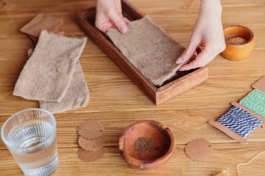 Mutfak bahçesi. Tohum ekmek için jüt hasırı hazırlayan, evde mikroçim yetiştiren bir kadın.