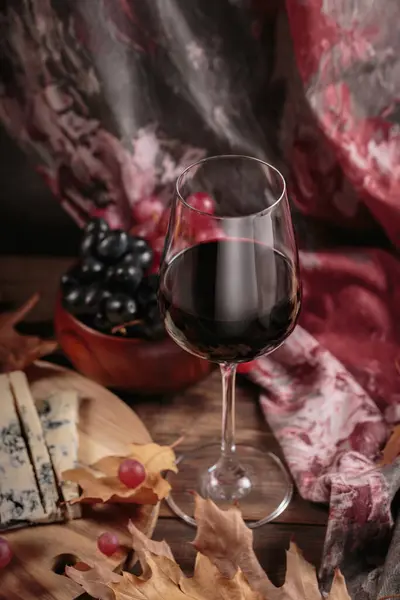 一杯红葡萄酒配上蓝色奶酪和深色木制底色 秋天野餐 用葡萄酒和奶酪盘 水果和干树叶做成乡村风格 — 图库照片