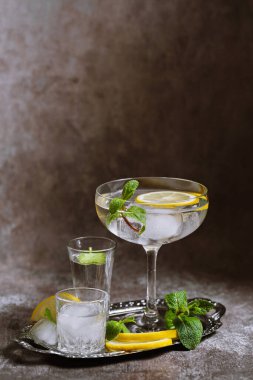 Gümüş tepside buzlu, limonlu ve nane arkaplanlı temiz soğuk içeceklerle dolu çeşitli bardakların toplanması. Kokteyl partisi, alanı kopyala