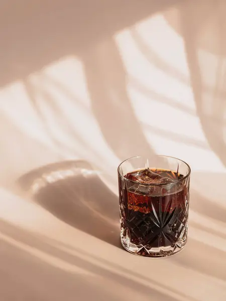 威士忌可乐鸡尾酒 高球杯中浓郁的酒精和冰块 浅米色背景 迷人的亮点 白天反射阳光 — 图库照片